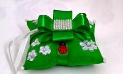 Cosimos una almohada verde para anillos de boda.