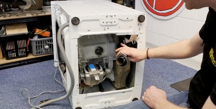 How to remove small objects caught behind the drum from a washing machine