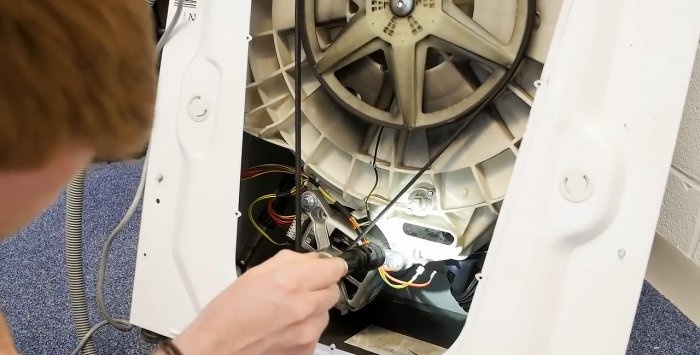 How to remove small objects caught behind the drum from a washing machine