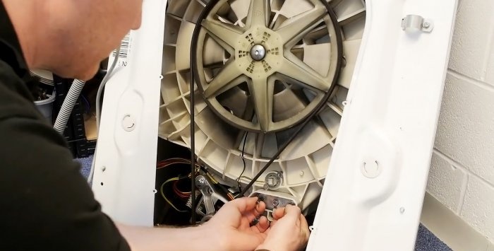 How to remove small objects caught behind the drum from a washing machine