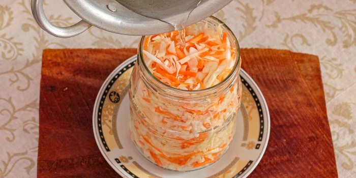 Pour warm marinade into containers with cabbage