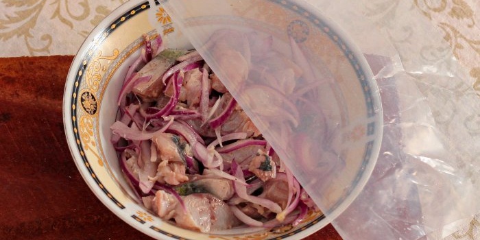 Cover the container with fish with cling film