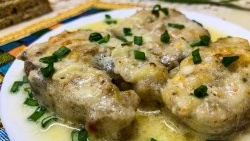 Pollock stewed in pieces in sour cream sauce in a frying pan