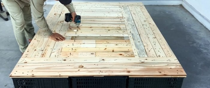 Bed made of plastic vegetable crates with numerous storage spaces