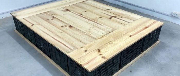 Bed made of plastic vegetable crates with numerous storage spaces