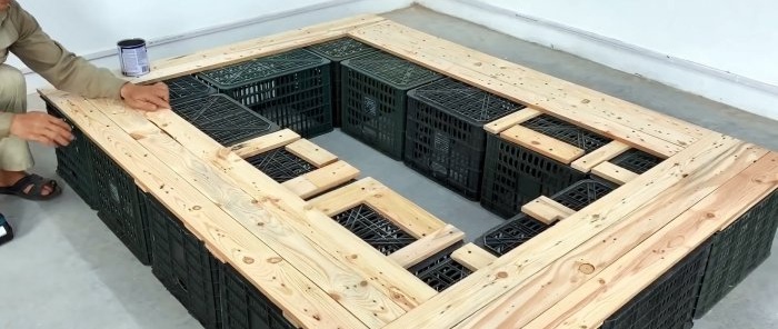 Bed made of plastic vegetable crates with numerous storage spaces