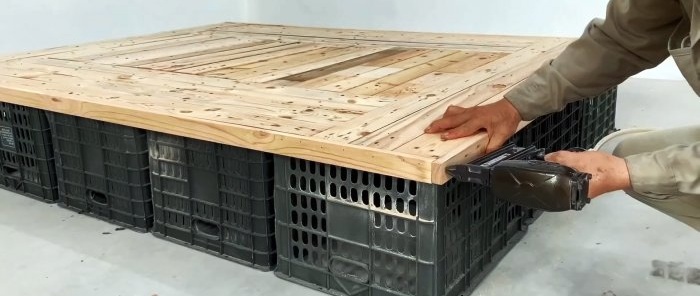 Bed made of plastic vegetable crates with numerous storage spaces